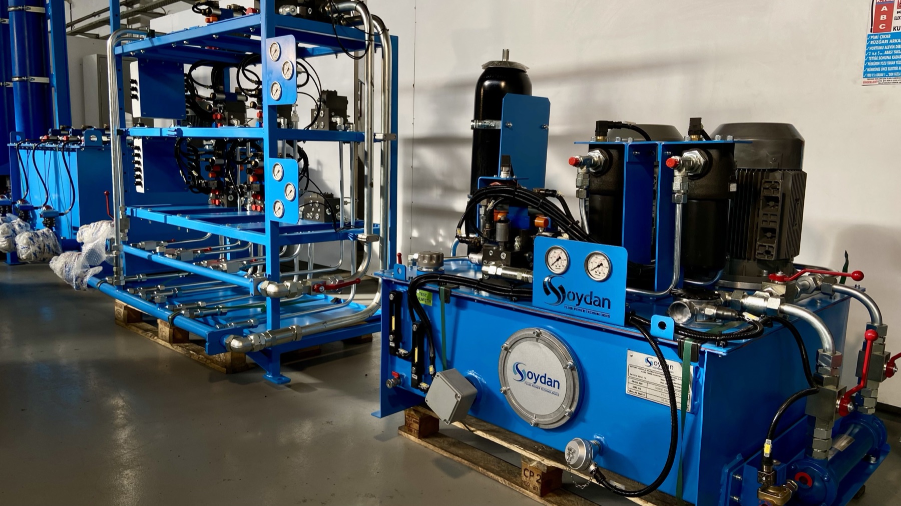 Soydan-branded hydraulic power units in the İzmir assembly bay — complete systems engineered in-house